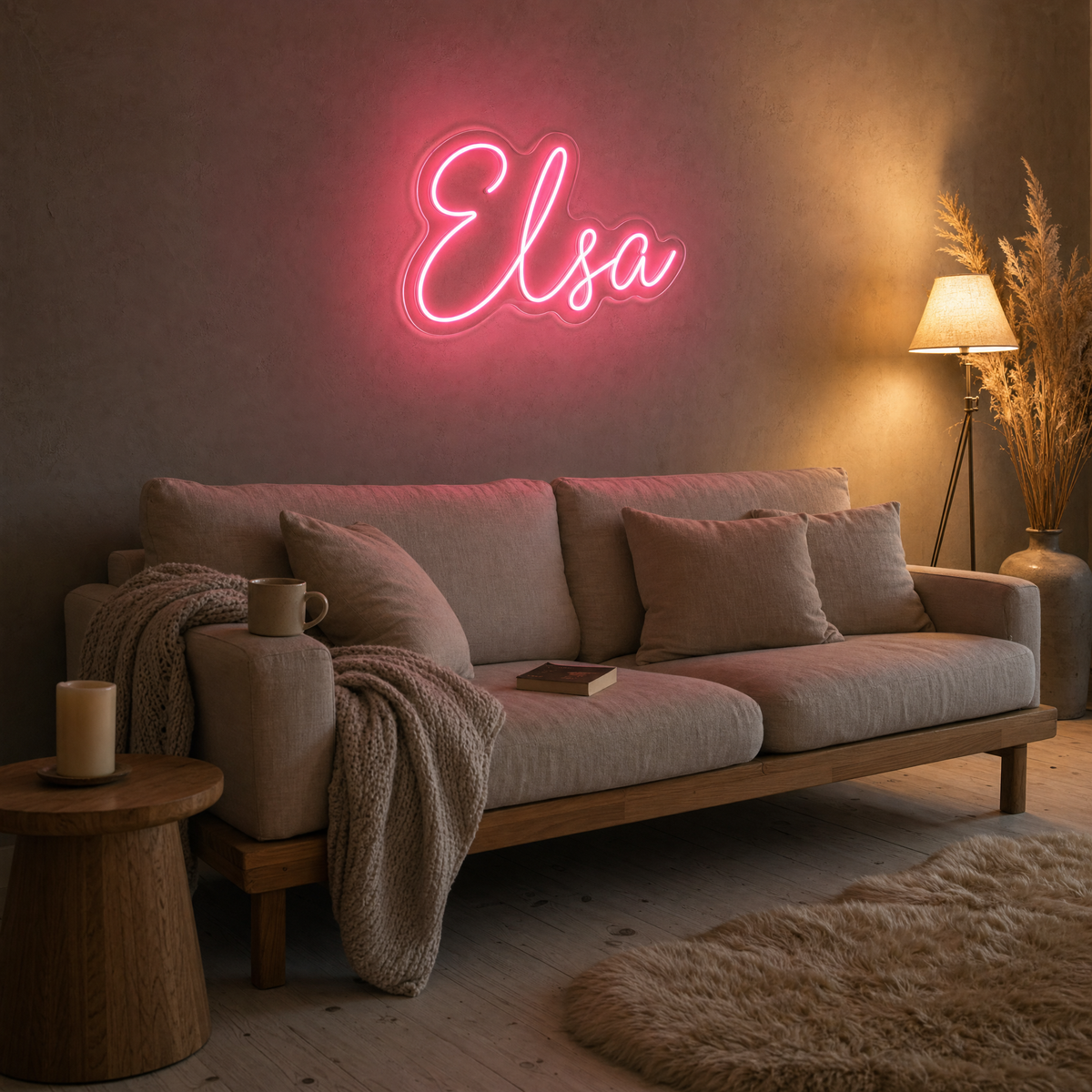 Rosa neonskylt med namnet Elsa och ett hjärta ovanför en soffa i ett varmt vardagsrum