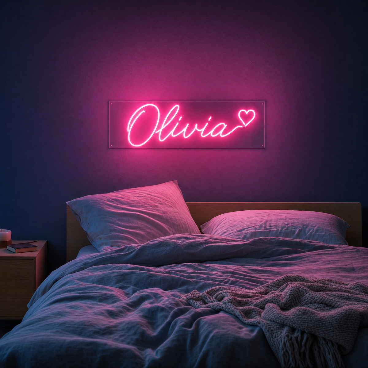 Rosa neonskylt med namnet Olivia och ett hjärta ovanför en säng i ett sovrum
